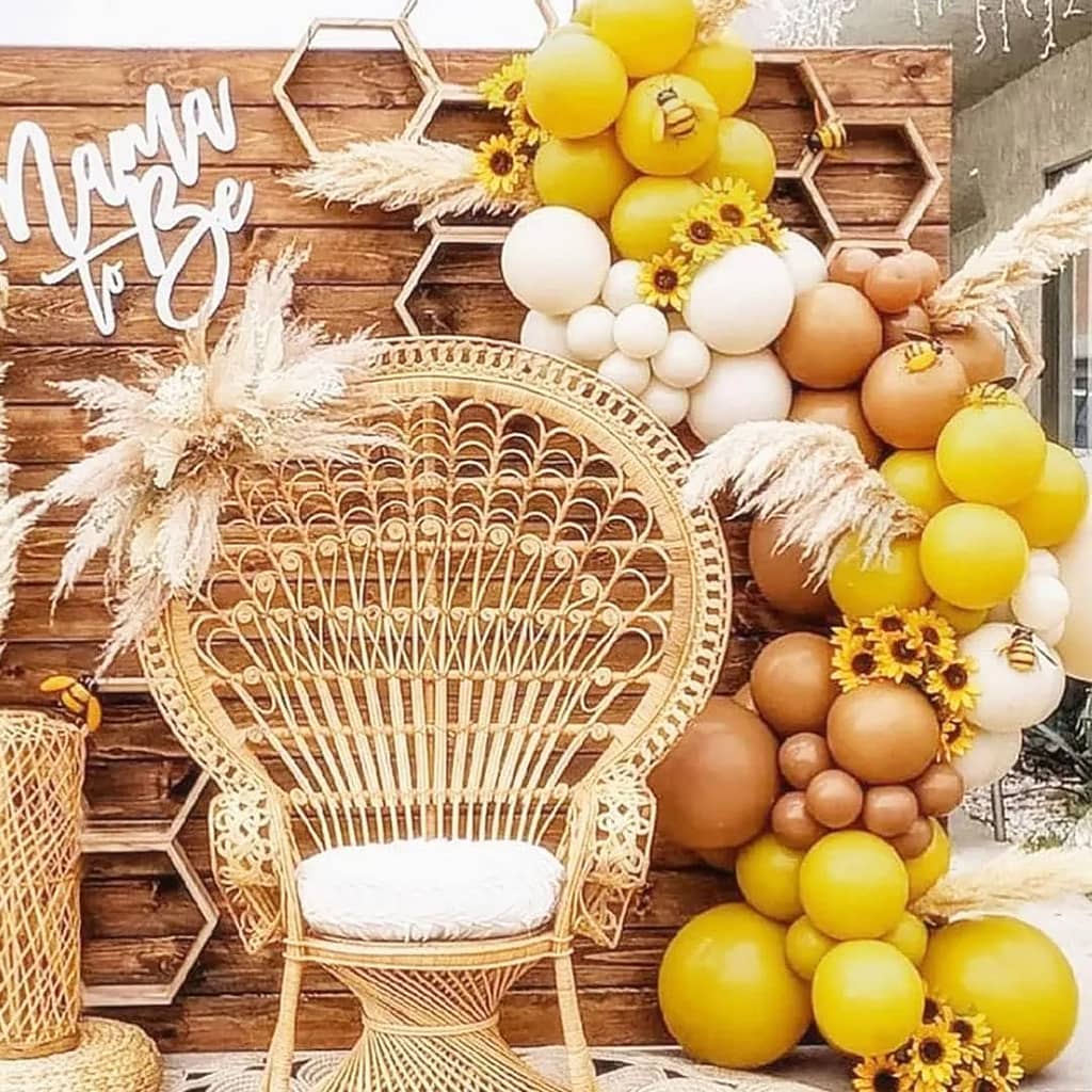mustard yellow and brown balloons in an arch over a boho chair