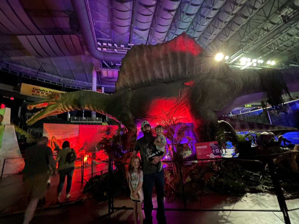 family standing in front of spinosaurus 