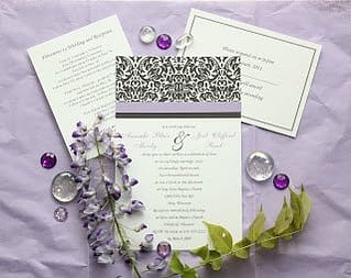 a simple black and white damask pattern across the top of a wedding invitation with purple accents