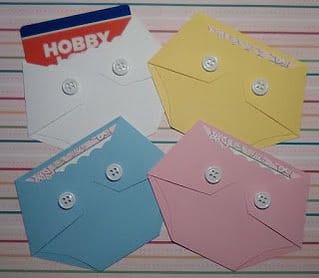 diaper shaped gift card holders holding a baby shower game prize