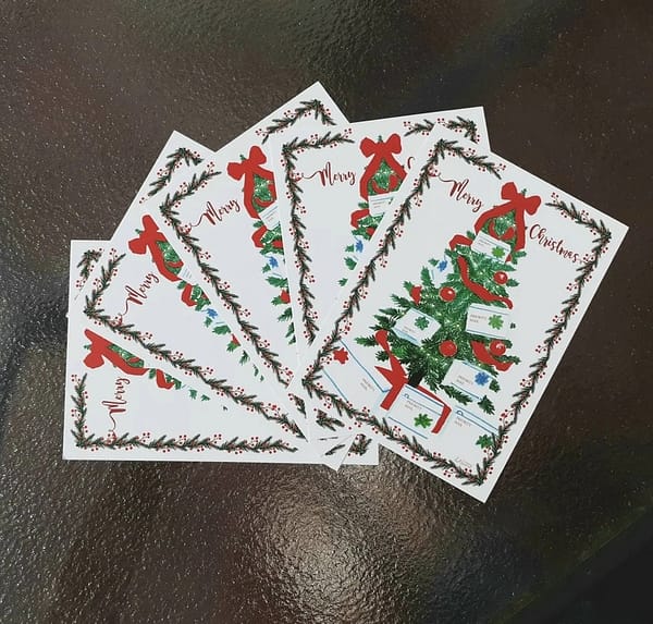 5 mail carrier postcards with a christmas tree fanned out on a table