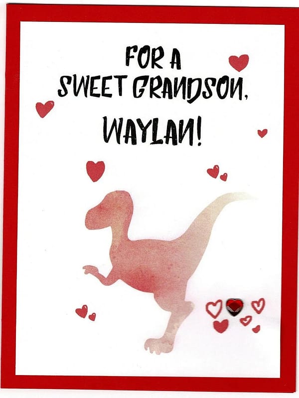 handmade valentine card with a red raptor dinosaur and some hearts on the front