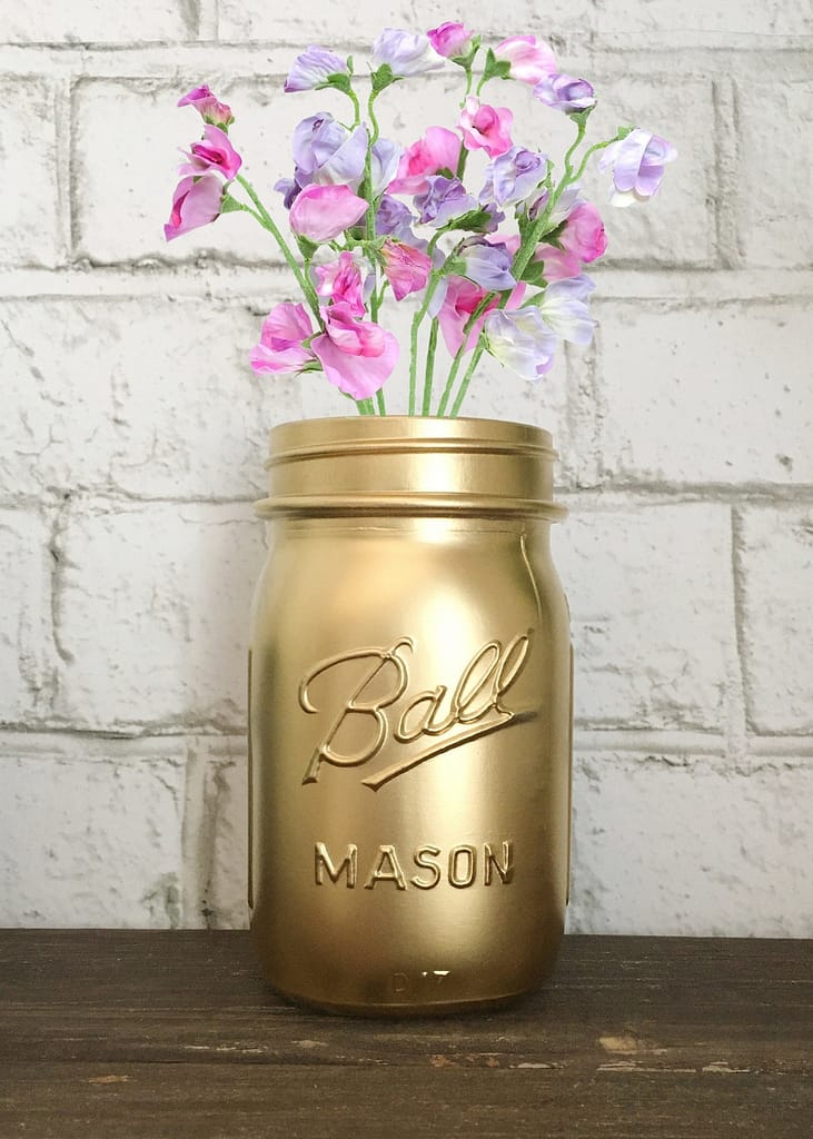 pink and purple sweet peas in a gold mason jar