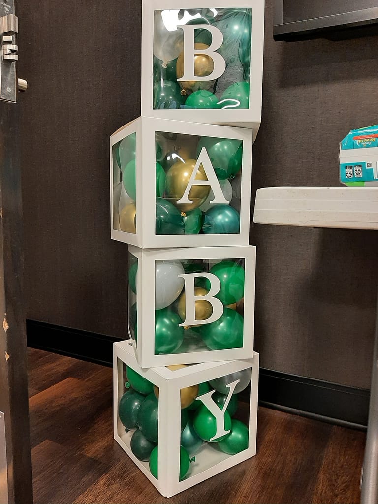 Baby box decoration with green and gold balloons