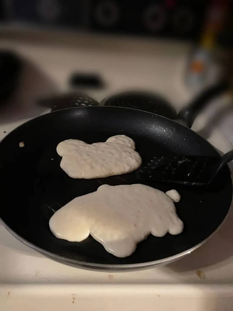 2 shaped pancakes cooking in a pan for easter breakfast