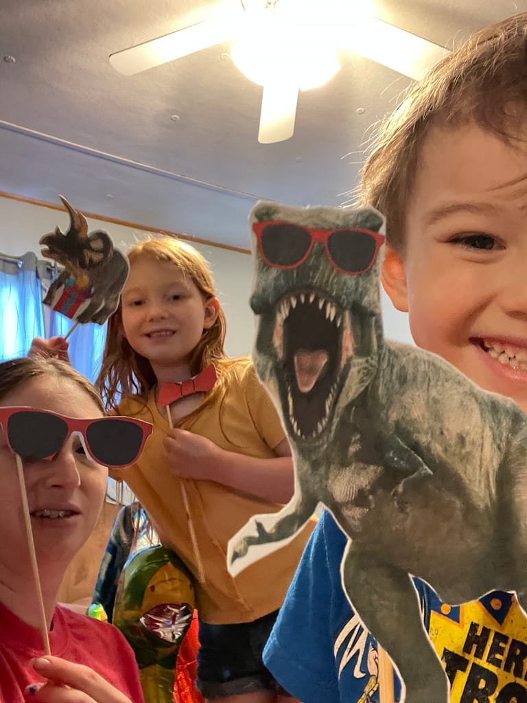 family taking photo with dinosaur props